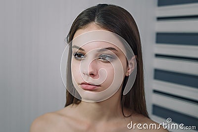 Beautiful teenage girl model getting professional make-up. Beauty portrait of female teenager in process of visage. Cosmetics Stock Photo