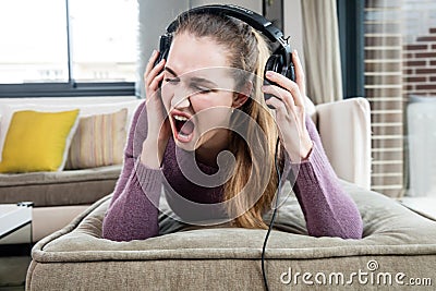 Beautiful teenage girl in pain screaming suffering from loud music Stock Photo