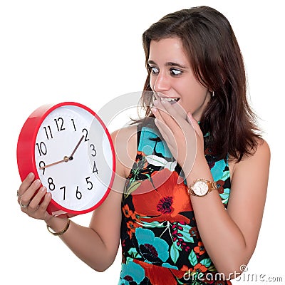 Teenage girl with a surprised expression checking the time on a big clock Stock Photo