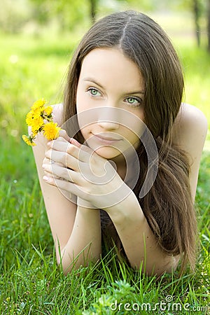 Beautiful teenager with dandelion on lawn Stock Photo