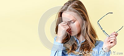 Beautiful teenager girl with ginger hair and freckles holding reading glasses, having headache and sore eyes. Stock Photo