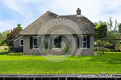 Beautiful thatched buildings in the famous village of Giethoorn in the Netherlands with water canals. Editorial Stock Photo