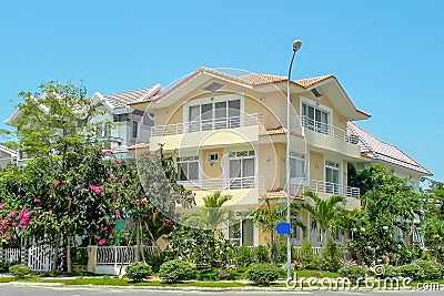 Beautiful three-story house with palm trees, trees, and landscape design in the summer Stock Photo