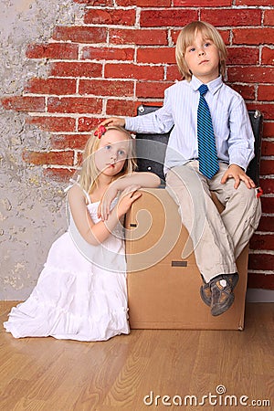 Beautiful tired children sitting on suitcases Stock Photo