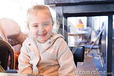 Beautiful toddler child girl sitting on baby highchair laughing Stock Photo