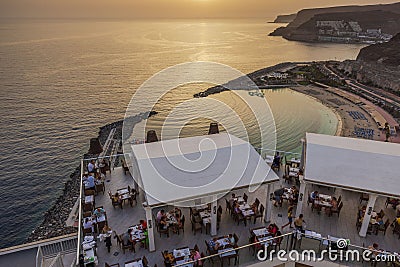 Beautiful top view of bustling waterfront restaurant filled with patrons on gorgeous sunset background. RIU hotel, Gran Canaria. Editorial Stock Photo