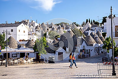 Beautiful town of Alberobello with typical trulli houses built from stone among green plants and flowers, main touristic district Editorial Stock Photo
