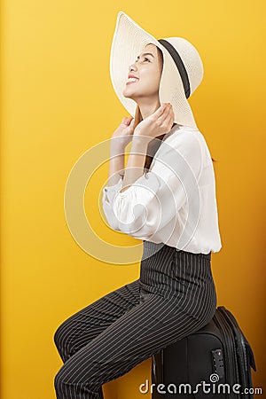 Beautiful traveler woman is exciting on yellow background Stock Photo