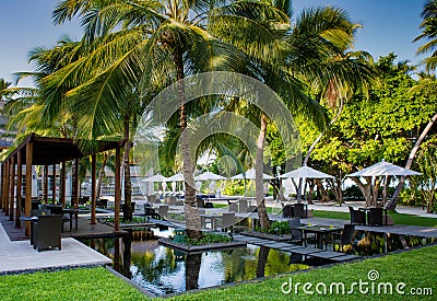 Beautiful tropical outdoors restaurant setup with tables in water surrounded by palm trees at Maldives Stock Photo