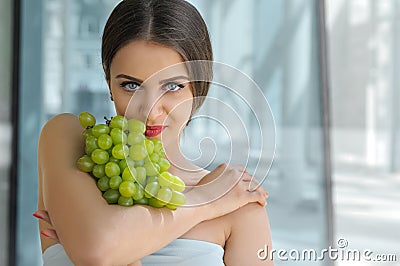 Beautiful turkish woman holding a bunch of grapes Stock Photo