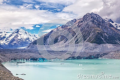 Beautiful turqouise Tasman Glacier Lake and Rocky Mountains in the clouds Stock Photo