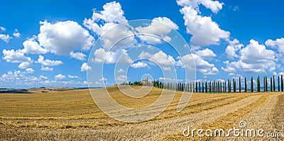 Beautiful Tuscany landscape with traditional farm house and dramatic clouds on a sunny day in Val dOrcia, Italy Stock Photo