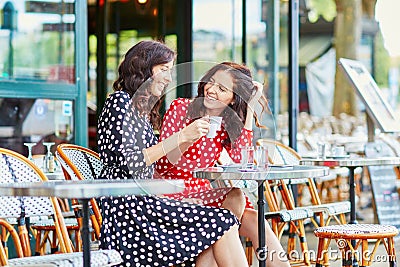 Beautiful twin sisters drinking coffee in Paris Stock Photo