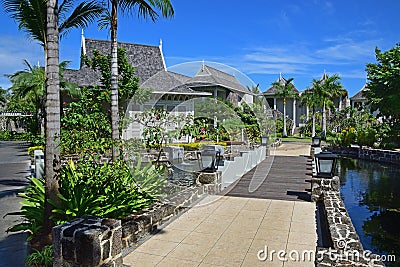 Beautiful upscale resort hotel with small wooden bridge connecting to the villas with abundant trees around Stock Photo