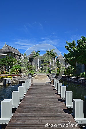 Beautiful upscale resort hotel with small wooden bridge connecting the walkway with the villas Stock Photo