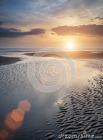 Beautiful vibrant Summer sunset over golden beach landscape with Stock Photo