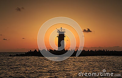 Beautiful Vibrant Sunrise Sky Over Calm Sea Water And Lighthouse Stock Photo