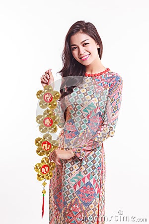Beautiful Vietnamese woman wearing impression ao dai holding lucky decorate object Stock Photo