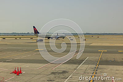 Beautiful view of airport runway on clear morning, with Delta airline plane being prepared for its flight. Editorial Stock Photo