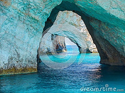 Beautiful view on Blue Caves rock arches from sightseeing boat with tourists in blue water of Ionian Sea inside Blue cave. Island Stock Photo