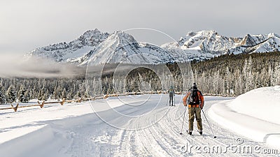 Beautiful view for cross country skiers trekking down a road to the mountains Stock Photo