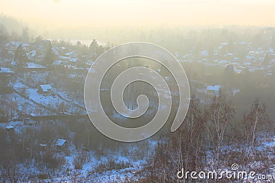 A beautiful view of the filling of the winter morning fog on the landscape of houses. Landscapes top view at sunset in Stock Photo