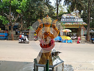 Beautiful view of Goddess Face in the Yellow Color Trishula or Trident in front of the Sri Gangamma Devi Temple Near Kadu Editorial Stock Photo