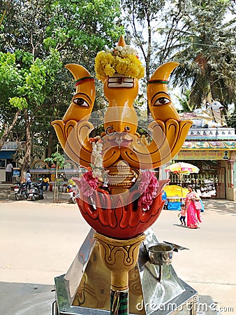 Beautiful view of Goddess Face in the Yellow Color Trishula or Trident in front of the Sri Gangamma Devi Temple Near Kadu Editorial Stock Photo