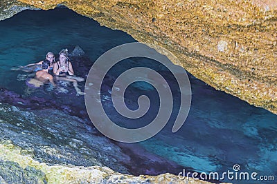 Beautiful view of group of young people swimming in gorge of rocks of Atlantic Ocean on island of Aruba. Editorial Stock Photo