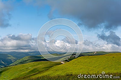 Beautiful view of idyllic alpine mountain scenery with blooming meadows and mountains on a beautiful sunny day with blue sky and Stock Photo
