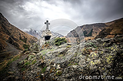 Beautiful view on impressive gorge in Caucasus mountains. Monument in form of Cross and path to it Stock Photo