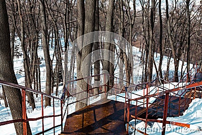 Beautiful view with an old rusty stairway in a snow-covered park Stock Photo