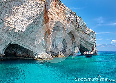 Beautiful view on rock arces arches of Blue caves and travel sightseeing boat with tourists in blue water. Famous Greece holidays Editorial Stock Photo