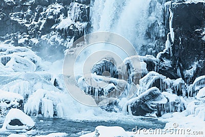 beautiful view of scenic waterfall, frozen river and snow-covered rocks in thingvellir national Stock Photo