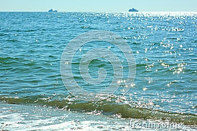 Sea travel. Beautiful view of the waves on a bright sunny day. Sun glare on the water. Ships sail away on the horizon Stock Photo