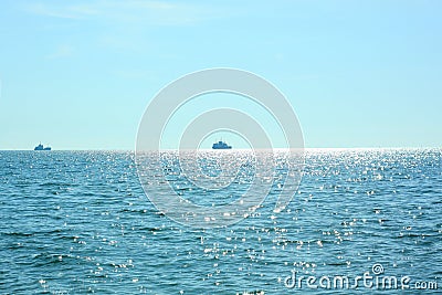 Sea travel. Beautiful view of the waves on a bright sunny day. Sun glare on the water. Ships sail away on the horizon Stock Photo