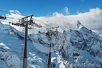 Beautiful view of snowy mountains peaks. Cable car in mountains.Skiers and snowboarders lift to the Ski Resort high in Stock Photo