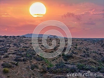 Beautiful view of sunset with red moody clouds and a barren land. Sunsetting, sunshine, clouds, moody clouds, barren land, sky Stock Photo