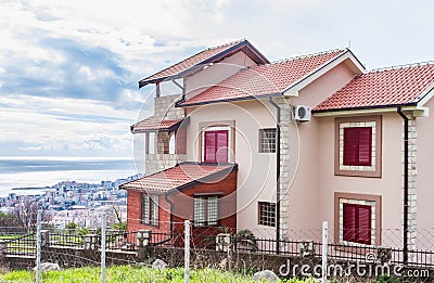 Beautiful view of a traditional residential building with a balcony near the mountain in Budva. Editorial Stock Photo