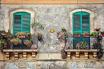 Beautiful vintage balcony with colorful flowers and doors Stock Photo
