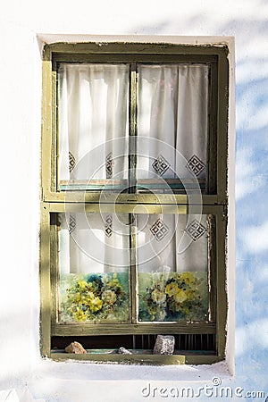 Beautiful vintage olive green decorated window on small house. Close up Stock Photo