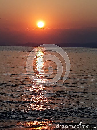 Beautiful warm colour sunrise with reflection on the sea Stock Photo