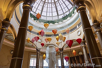 A beautiful water fountain with statues, tall pillars, Chinese lanterns and lush green plants at The Venetian Resort and Hotel Editorial Stock Photo