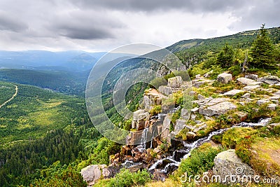 Beautiful waterfall above a deep green valley in the mountains Stock Photo