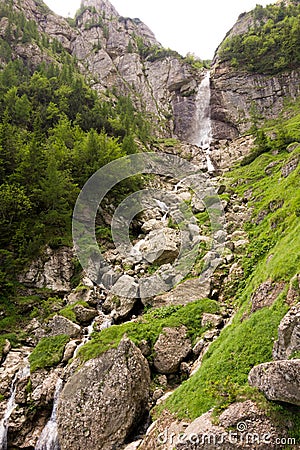 Beautiful waterfall on a rocky valley with scattered vegetation Stock Photo