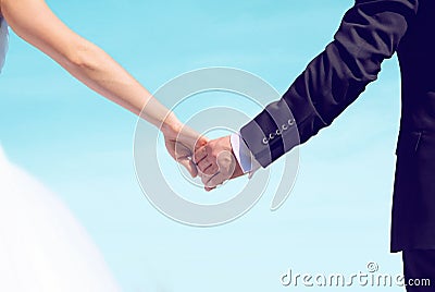 Beautiful wedding couple, bride and groom holding hands looking Stock Photo