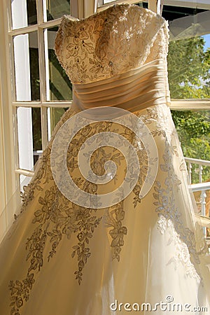 Beautiful wedding gown hanging in window Stock Photo