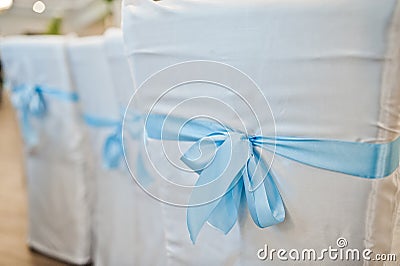 Beautiful wedding set decoration in the restaurant. Blue ribbons on chairs Stock Photo