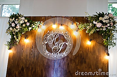 Beautiful wedding set decoration in the restaurant. Rustic wooden photo zone with bulb lamps Stock Photo