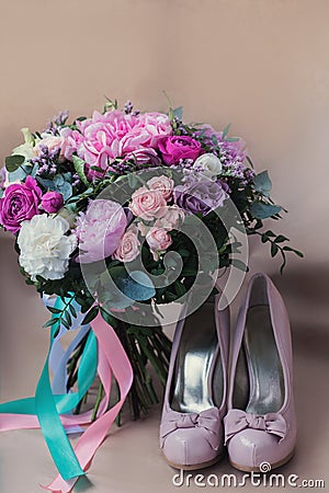 Beautiful wedding shoes with high heels and a bouquet of colorful flowers Stock Photo